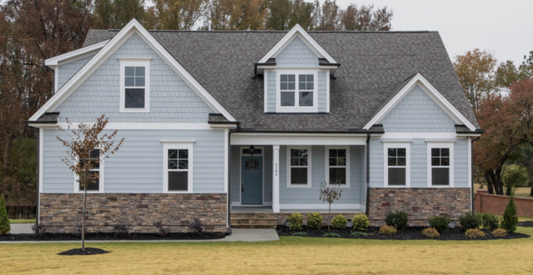 A fiber cement home with blue-gray siding accented by white trim and natural stone details.